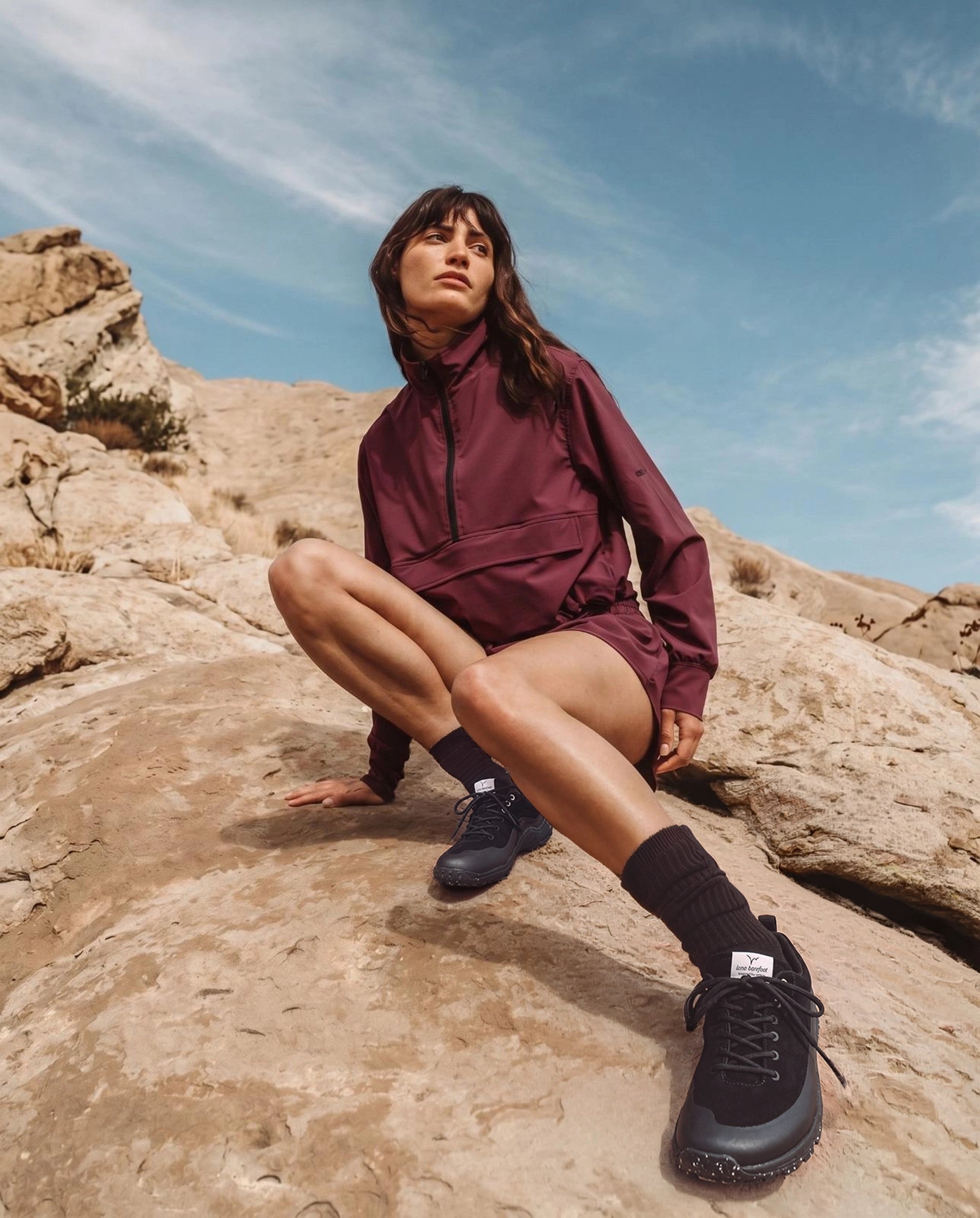 WILD Inked Female Posing On Rocky Terrain with Wide Toe Box Minimalistic Hiking Shoes