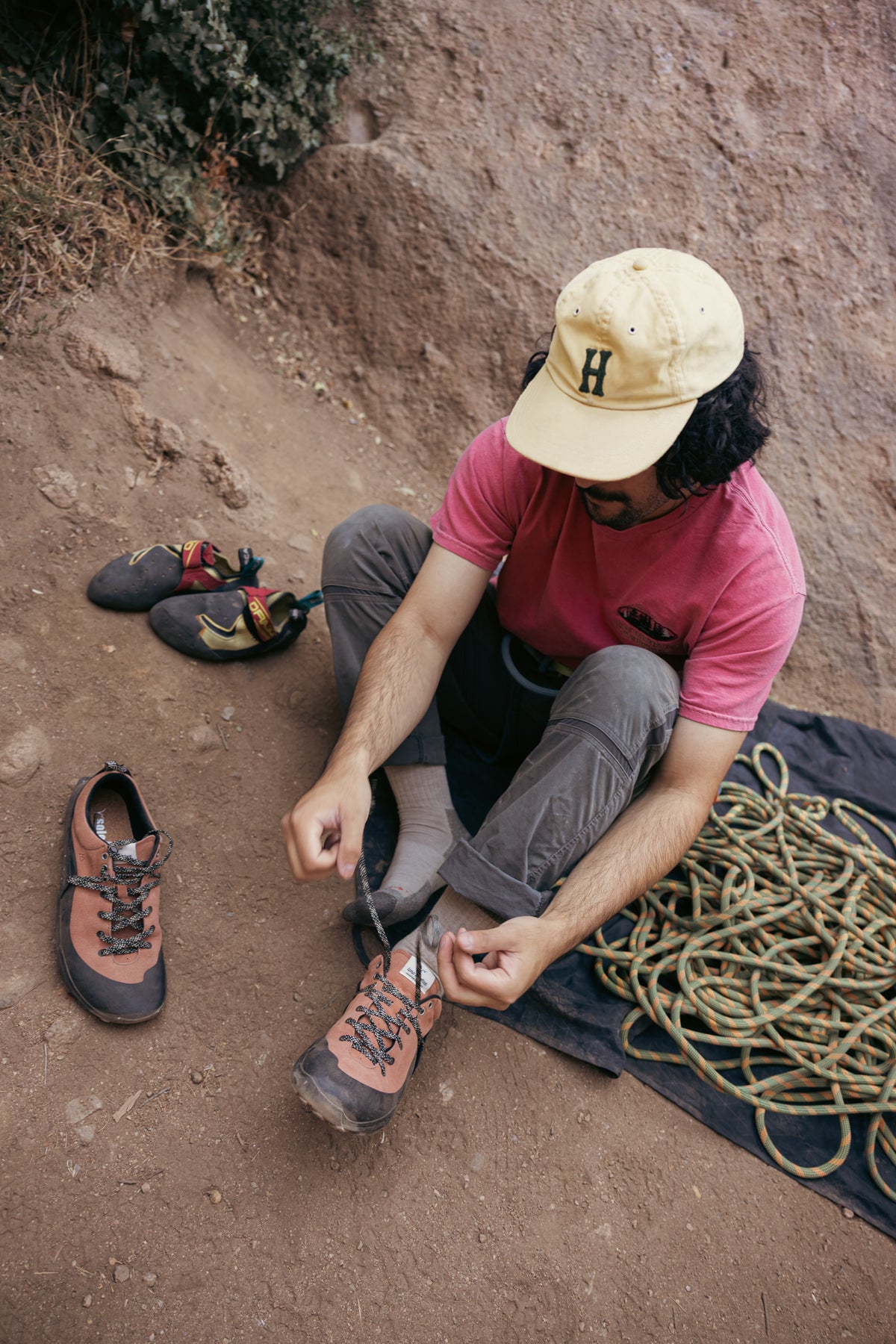 Climber lacing LONO WILD barefoot shoes near rock