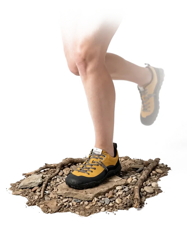 Runner landing in a LONO WILD shoe on a rocky trail patch, knee visible