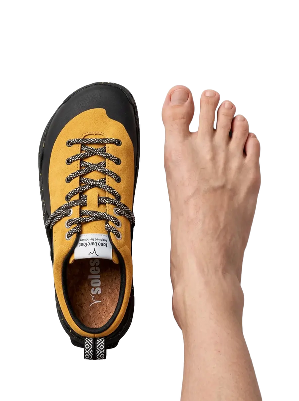 Top-down view of a LONO WILD shoe beside a bare foot with toes spread